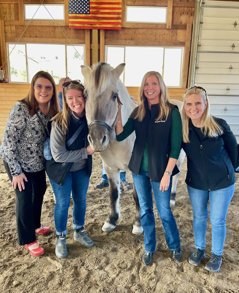 Women from Peoples Bank posing with horse from Alatheia Theraputic Riding Center