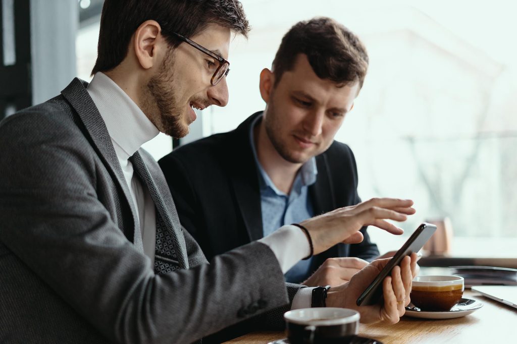 Two businessmen having a conversation using a smartphone